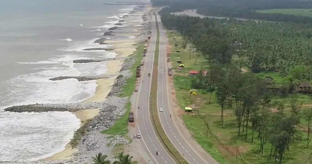 National Highway corridor with roadside vegetation along the coastal landscape