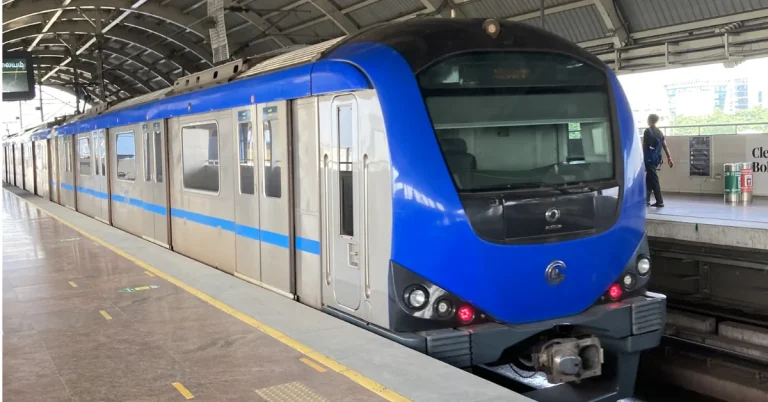 Blue Chennai Metro train standing at a covered metro station platform