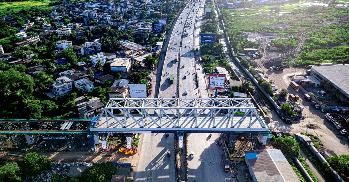 Steel bridge structure spanning a highway as part of the Mumbai-Ahmedabad Bullet Train project