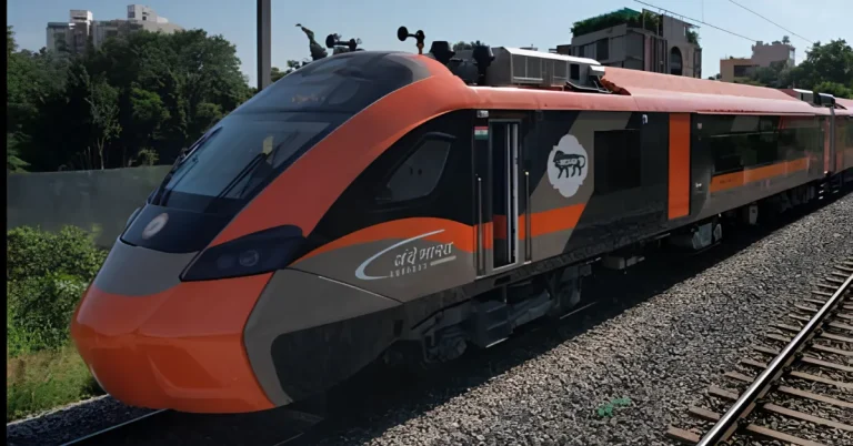 Vande Bharat Sleeper train with orange and grey aerodynamic design running on an electrified railway track, representing the Varanasi–Delhi overnight service.